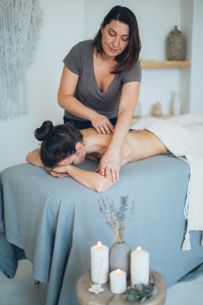 A serene spa setting with a therapist giving a back massage to a female client for relaxation.